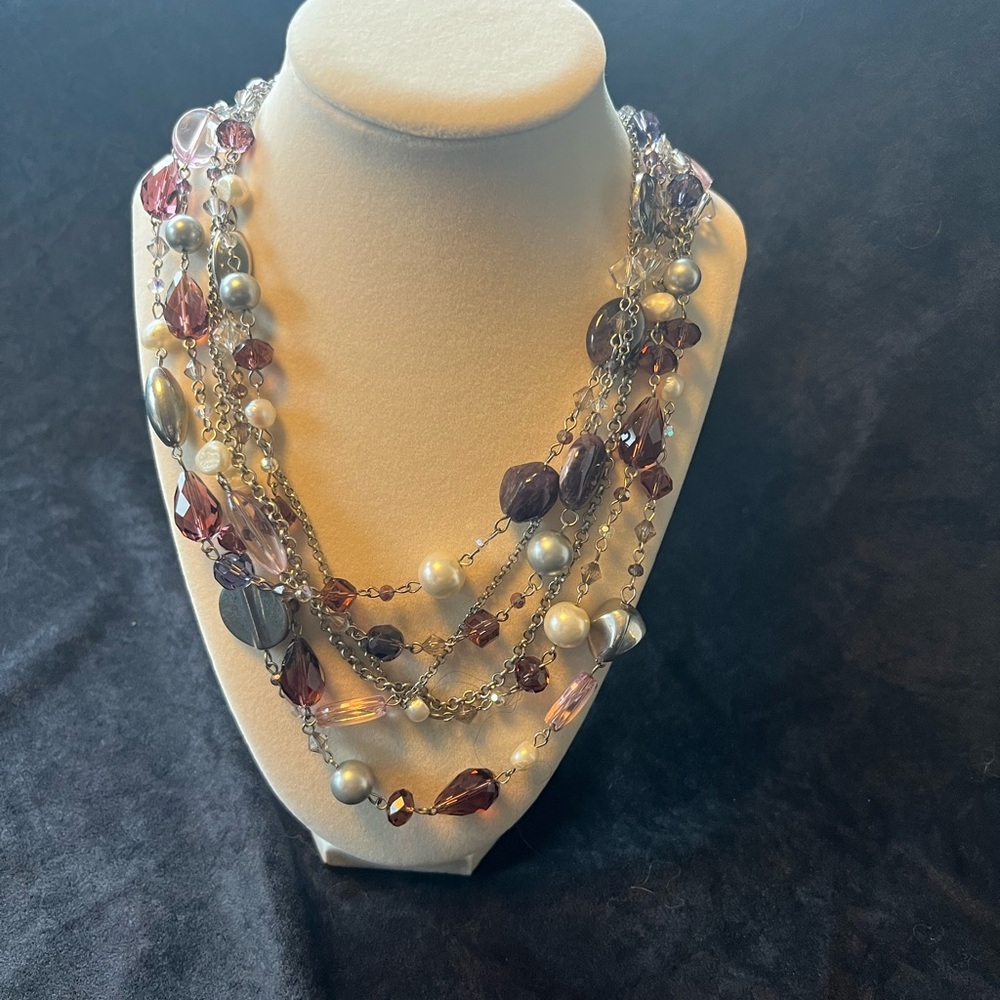Necklace with Strands of purples, white, grey and silver.